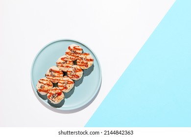 Hot sushi roll with cream cheese top. Baked sushi with seafood and crab, cream cheese topped. Hot maki sushi  on coloured background in minimal style - Powered by Shutterstock