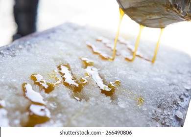 Hot Syrup Lying On A Snow Bank To Make Maple Lollipops. Photo Taken During Sugar Shack Period In Quebec, Canada