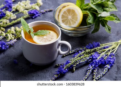 Hot tea with mint lemon in a white cup on a dark background. - Shutterstock ID 1603839628