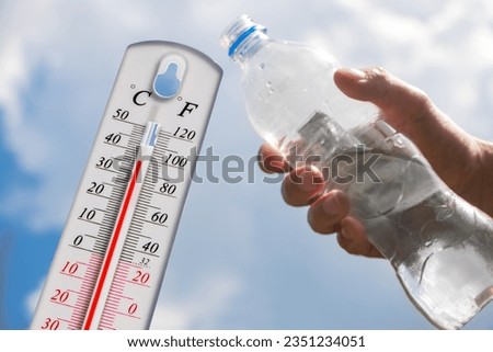 hot temperature,Thermometer and water bottle on sky with sun shining in summer show higher Weather, concept global warming.