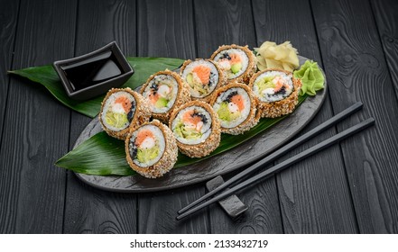 Hot tempura roll with salmon and cheese, Traditional delicious fresh sushi roll set on a black background. Sushi menu. Japanese kitchen, restaurant. Asian food