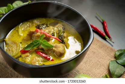 Hot Thai chicken green curry or Kiew Wan curry on table with spices & herbs.  Thai Chicken green curry is a tasty traditional Thai food made from coconut milk & green curry paste. Thai food concept. 