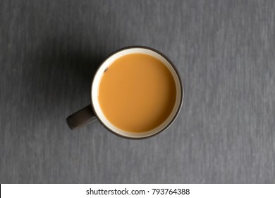 Hot Thai Orange Tea With Milk In Brawn Cup On The Grey Tablecloth, Copy Space, Top View