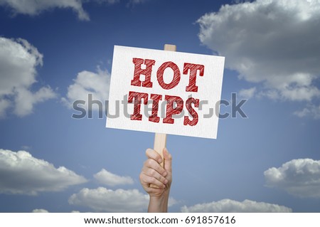 Hot tips message on board in hand with clouds background