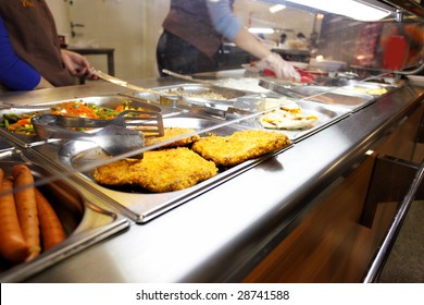 Hot trays with cooked food close-up in dining room