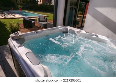 hot tub on outdoor terrace with swimming pool next to the house