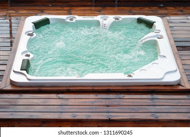 Hot Tub. Pool Cleaner During His Work. Hotel Staff Worker Cleaning The Pool