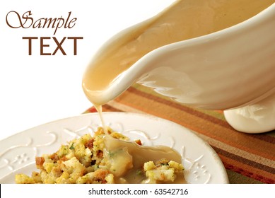 Hot Turkey Gravy Being Poured Over Plate Of Stuffing On White Background With Copy Space. Slight Motion Blur On Drip.