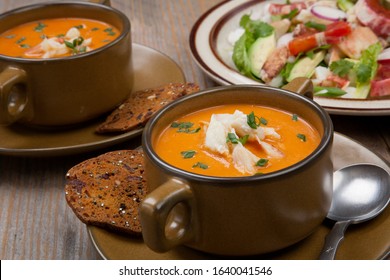 Hot Two Bowls Of Crab Bisque Garnished With Fresh Cooked Dungeness Crab Meat And Green Chives. Garnished With Whole Grain Crackers. Rustic Style.