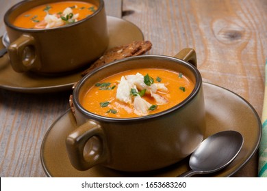 Hot Two Bowls Of Crab Bisque Garnished With Fresh Cooked Dungeness Crab Meat And Green Chives. Garnished With Whole Grain Crackers. Rustic Style.