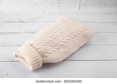 
Hot Water Bottle In A White Knitted Cover