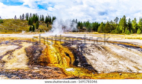 Hot\
water from the Middle Chain Lake Geyser and surrounding Hot Springs\
flowing into the Firehole River in the Upper Geyser Basin along the\
Continental Divide Trail in Yellowstone, Wyoming,\
USA
