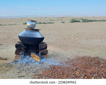 Hot water in winter on conventional Indian chulha in open groud background  - Shutterstock ID 2238249961