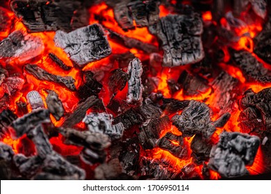 Hot white and black coals smolder in the grill
