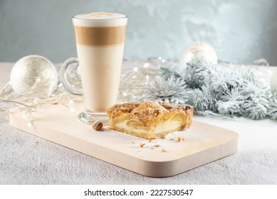 Hot winter drink whith pie.  layered latte coffee on the table. Cozy home atmosphere, white background, copy space for text. Winter holidays treats concept