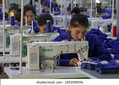 HOTAN, CHINA - APRIL 27 2019. Uigur Women Work In A Cloth Factory In Hotan County, Xinjiang Province, China.