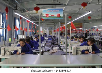 HOTAN, CHINA - APRIL 27 2019. Uigur Women Work In A Cloth Factory In Hotan County, Xinjiang Province, China.