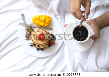 Hotcakes with fruit and coffee in bed