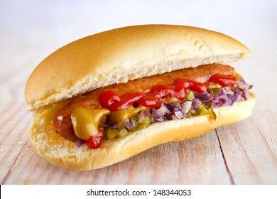 Hotdog With Ketchup, Mustard, Cucumber Relish And Red Onion