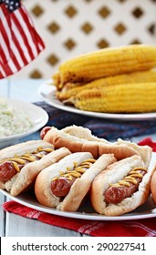 Hotdogs With Mustard, Cole Slaw And Corn On A Cob At A 4th Of July BBQ Picnic.