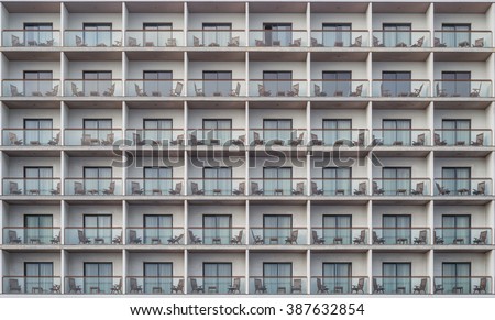 Hotel apartment balcony texture pattern. Detail of the facade of a apartment building, outdoor view of rows of balconies / terrace / gallery always equipped with small table and two chairs / seats.