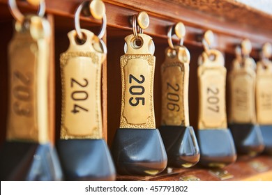 Hotel Bronze Keys With Room Numbers Hanging At Reception Desk Counter