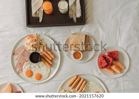 Hotel complimentary breakfast sets served on white bed.