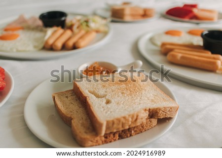 Hotel complimentary breakfast sets served on white bed.