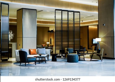 Lobby-Interieur mit Rezeption, Sofas, Marmorboden und langer Bar.