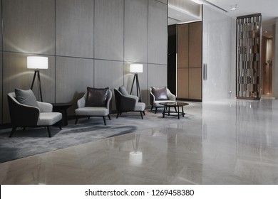 Interno della hall dell'hotel con reception, divani, pavimento in marmo e lungo bar.