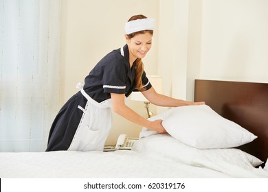 Hotel Maid Making Bed In Hotel Room During House Keeping