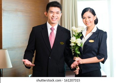 Hotel Manager Or Director And Supervisor Welcome Arriving VIP Guests With Roses On Arrival In Luxury Or Grand Hotel