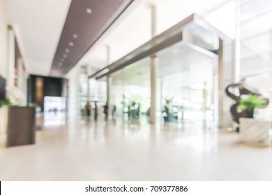 Hotel or office building lobby blur background interior view toward reception hall, modern luxury white room space with blurry corridor and building glass wall window