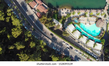 Hotel on the beach, beach with umbrellas and swimming pools, road among the trees, drone photo - Shutterstock ID 1528393139