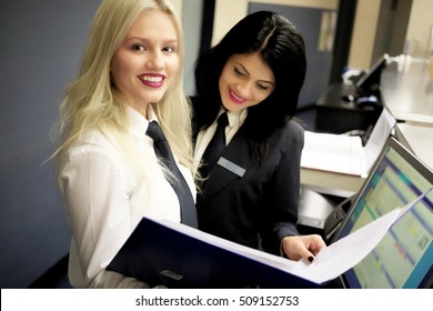 Hotel Receptionist. Modern Luxury Hotel Reception Counter Desk With Bell. Happy Female Receptionist Worker Standing At Hotel Counter.