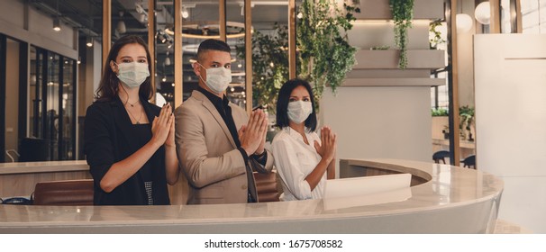 Hotel Receptionist Wearing Medical Mask And Show Greeting With Thai Wai For Being New Greeting Practice During Coronavirus Covid 19 Pandemic, New Greeting Practise In Coronavirus Covid 19 Pandemic