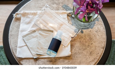 Hotel, Resort, Hospitality And Travel Safe Travel Kit For Personal Hygiene Anti-covid 19 Placed On A Coffee Table. Natural Cotton Bag, Alcohol Wipes, A Bottle Of Alcohol Gel And A Hygienic Face Mask.