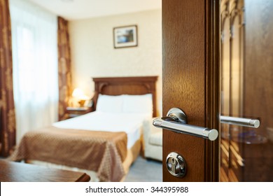 Hotel Room Or Apartment Doorway With Open Door And Bedroom In Background