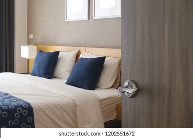 Hotel Room , Condominium Or Apartment Doorway With Open Door In Front Of Bedroom Background