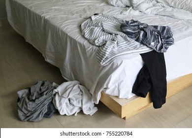 Hotel Room With Messy Clothes Scatter On The Bed And Floor