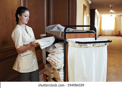 Hotel Room Service. Female Housekeeping Worker With Bedclothes Linen In Cart 