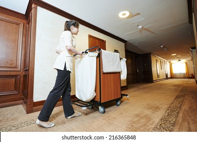 Hotel Room Service. Female Housekeeping Worker With Bedclothes Linen In Cart