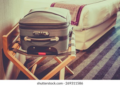 Hotel Room With A Suitcase On The Luggage Place And The Bed. Filtered Shot