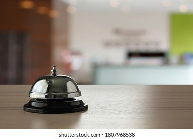 Hotelservice-Glocke auf Holzhintergrund
