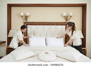 Hotel Service. Female Housekeeping Worker Maid Making Bed With Bedclothes At Inn Room