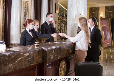 The Hotel Staff Serves Guests In Medical Masks