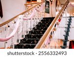 Hotel staircase leading to the ballroom, beautifully decorated for a wedding event, with elegant floral arrangements and a romantic ambiance