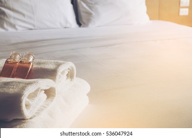 Hotel Towel With Shampoo And Soap Bottle Set On White Bed