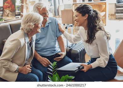 A hotel or travel agency representative is talking with a senior tourist couple offering various tourist services - Powered by Shutterstock