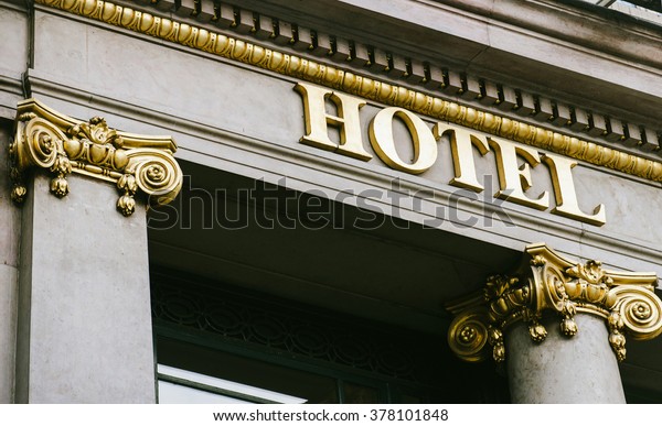 Hotel word with golden letters on luxury hotel\
with beautiful columns